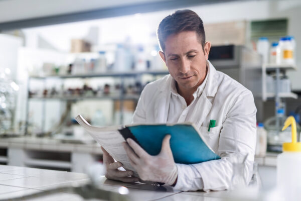 Mid adult male scientist reading scientific data in a laboratory.