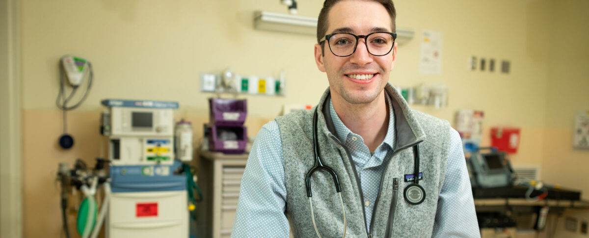 Post-Baccalaureate Pre-Medical student smiling wearing a stethoscope in a medical setting