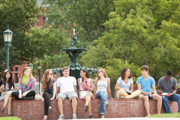 Students sitting around a fountain